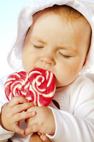 Baby eating a sugar lollipop