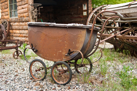 Baby carriage rusting on a farm