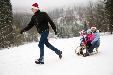 Family sledding with holiday gifts
